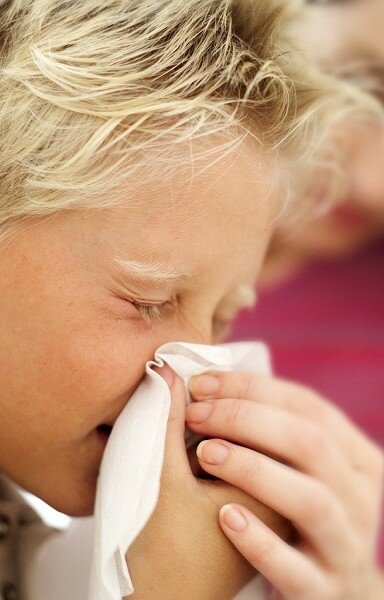 простуженный ребенок вытирает нос платком